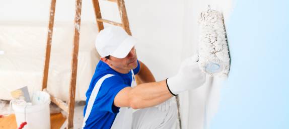 Painter with white cap painting the wall
